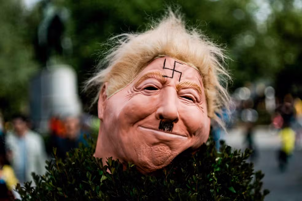 Uma máscara retratando o presidente dos Estados Unidos, Donald Trump, com uma suástica na testa, é exibida durante o protesto “No Kings” contra as políticas do governo, em Nova York, em 18 de outubro de 2025. — Foto: REUTERS/Eduardo Munoz