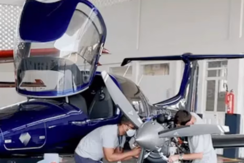 Dois funcionários realizam a manutenção de um avião bimotor em um galpão da AEROMOT - reprodução